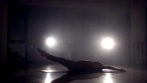 Man doing leg exercises on the floor in the hall. 4K Stock Footage 72330291