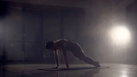 Man doing leg exercises on the floor in the hall. 4K Stock Footage 72576780