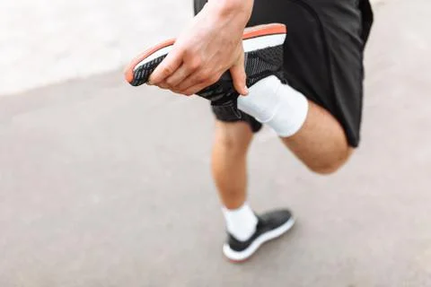 A man doing a leg stretch before Jogging, morning training, listening to musi Stock Photos