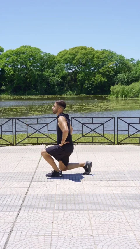 Man doing lunges in an urban park on a sunny day Video stock 316846490