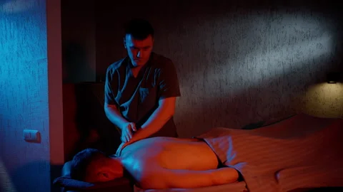 Man doing massage in red and blue light. Slow motion of the arms. Massage and Stock Footage 256620983