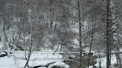 Man doing Norwegian walking along the suspension bridge over the river at winter Stock Footage 47548355