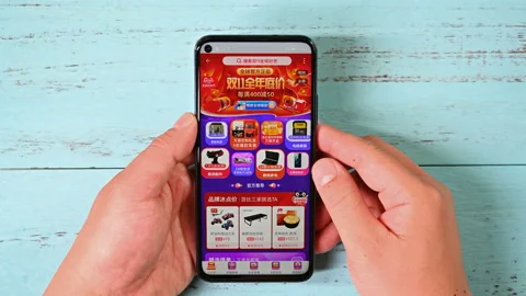 Man doing online shopping on a mobile app named TaoBao Stock Footage