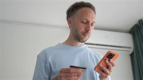 Man doing online shopping or making purchase in online store, holding smartphone Stock Footage 250088672