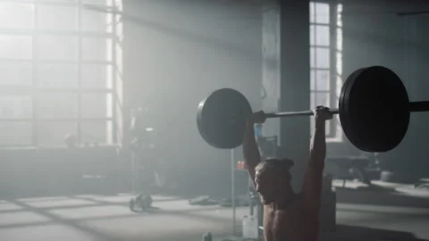 Man doing overhead squat with barbell during. Strong sportsman lifting weights Stock Footage 157526668