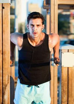 Man doing parallel bar dips to music on sports ground Stock-Fotos