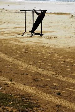 Man doing parallel bars on the beach 스톡 사진