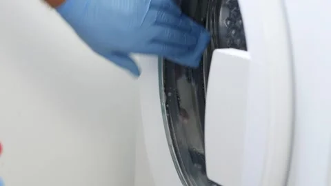 Man Doing Periodic Maintenance, Cleaning the Washing Machine. A Housekeeper Stock Footage 321247545