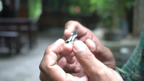 A man doing personal hygiene cutting his fingernails in the park Stock Footage 227458320