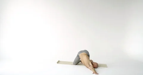 Man is doing physical exercises in white studio, lying on sportive mat and Stock Footage 119358122