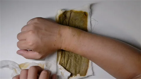 Man doing physiotherapy on his hurted hand with Chinese medicine nearby Stock Footage 106069740