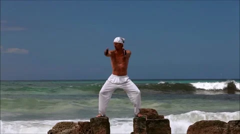 Man doing pilates on rocks in ocean I Stock Footage 41708833