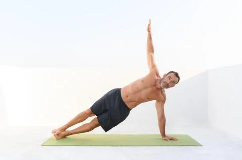 Man doing plank exercise on mat Stock Photos