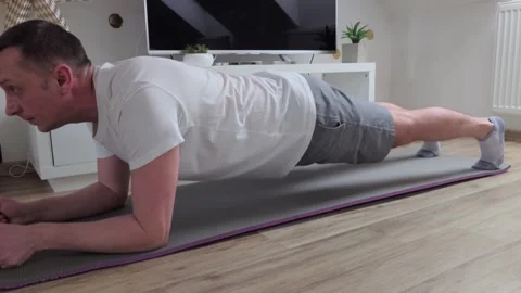 A man is doing a plank on a mat Video stock 328258430