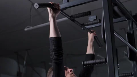 A man doing pull-ups on a horizontal bar in a gym Stock Footage 312063585