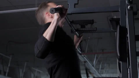 Man doing pull-ups on horizontal bar in gym, side view Vidéo 312067077