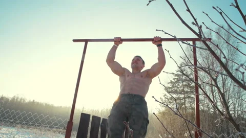Man doing pull ups sports activities with a naked torso outdoor. Video stock 148492171
