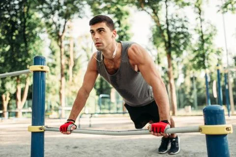 Man doing push-up exercise using horizontal bar 스톡 사진