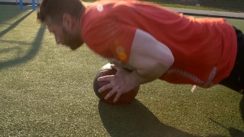 Man doing push up on medicine ball and throw it away Free Stock Footage 127033828
