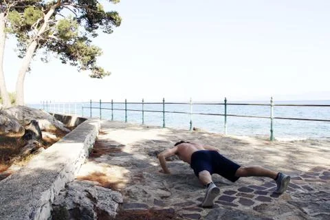 Man doing push-up outdoors Stock Photos