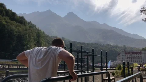 Man doing push ups on bars. Young athletic shirtless man dressed in sports Video stock 97365039
