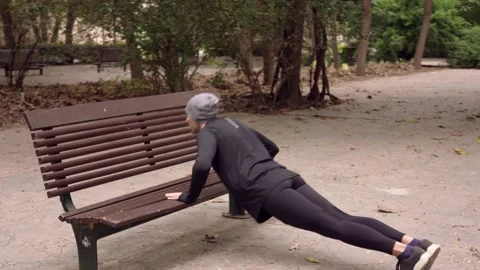 Man doing push-ups from bench outdoors Stock Footage 132050275