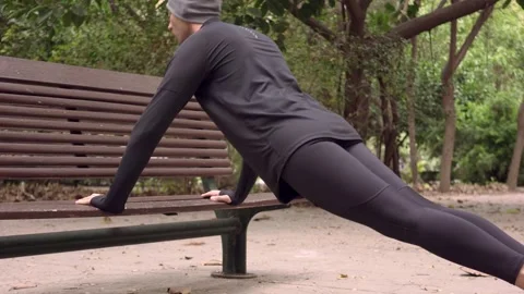 Man doing push-ups from bench in city park Stock Footage 132052220