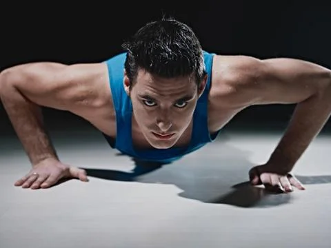 Man doing push-ups on black background Stockfoto's