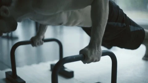 Man doing push-ups on dip bars at the gym Stock Footage 127435415