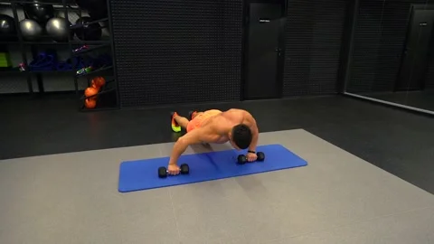 Man doing push-ups with dumbbells in the gym Stock Footage 211652441