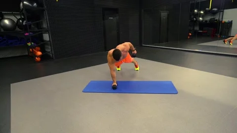 Man doing push-ups with dumbbells in the gym Stock Footage 211654102