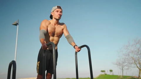Man doing push ups exercises on parallel bars Stock Footage 234401017
