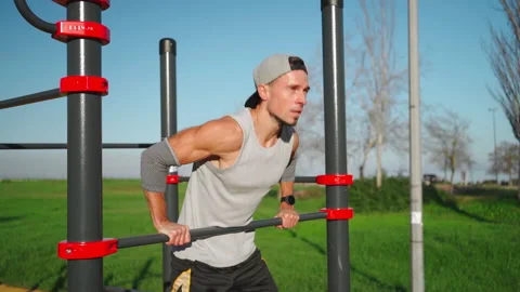 Man doing push ups exercises on parallel bars Stock Footage 234885203