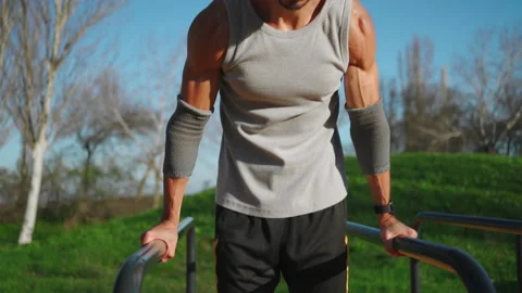 Man doing push ups exercises on parallel bars Stock Footage 237758092