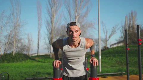 Man doing push ups exercises on parallel bars Stock Footage 238519333