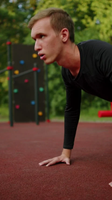 Man doing push-ups at an outdoor fitness ground. close up of a Young sporty.. Vidéo 341728321