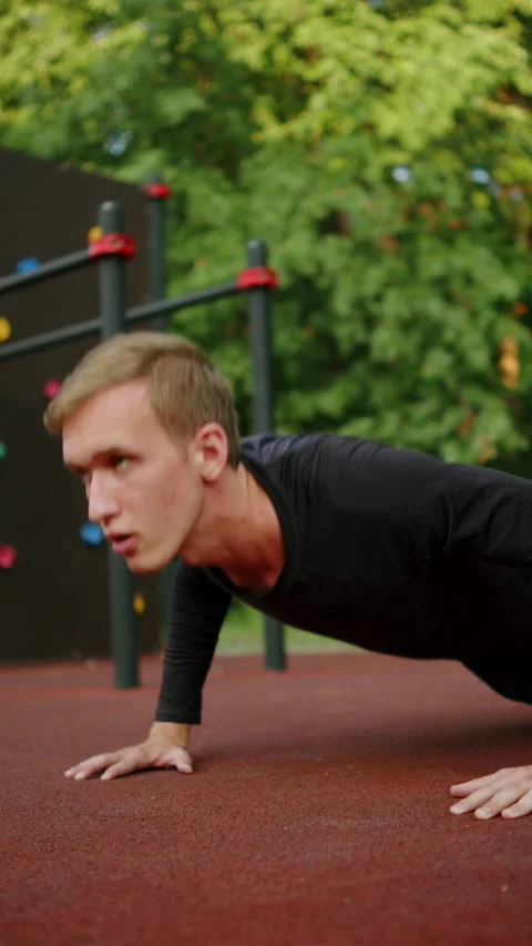 Man doing push-ups at an outdoor fitness ground. close up of a Young sporty.. Stock Footage 341728343