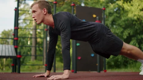 Man doing push-ups at an outdoor fitness ground. Young athletic man doing p.. Stock Footage 341729918