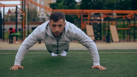 Man is doing push-ups outdoors Stock Footage 95204931