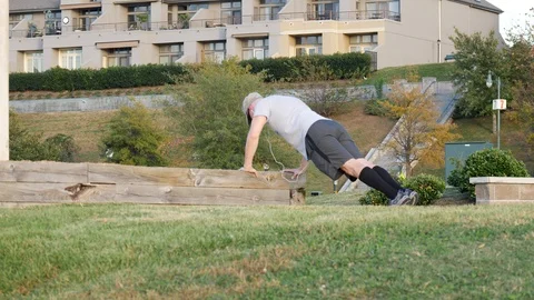 Man doing push-ups in park on summer day Stock Footage 88899069