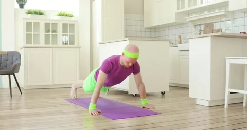 Man doing push-ups sport exercises on mat in kitchen at home, training himself. Stock Footage 131234068