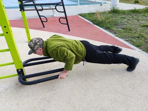 Man doing push-ups on the street sports ground Stock Photos