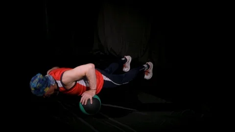 Man doing Push-ups using one medball, alternately rolling it from hand to hand Stock Footage 124898317