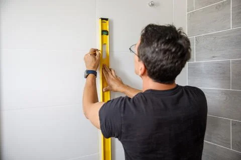 A man is doing repairs in the bathroom. Stock Photos