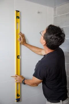 A man is doing repairs in the bathroom. Stock Photos