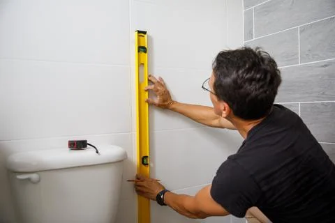 A man is doing repairs in the bathroom. Stock Photos