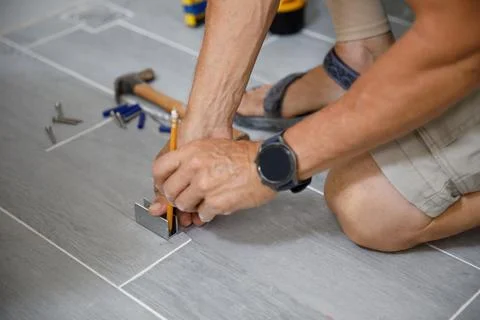 A man is doing repairs in the bathroom. Stock Photos