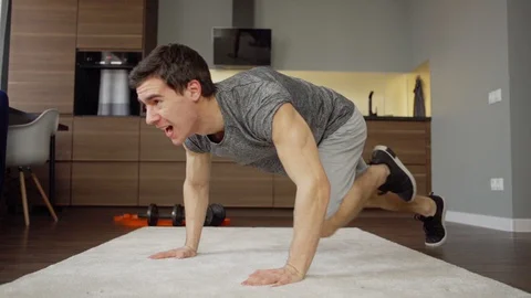 Man doing running plank challenge at home Stock Footage 128763778