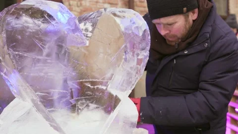 Man doing sculpture of big ice heart Stock Footage 171915580