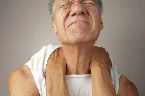 Man doing a self-massage on his upper back and shoulders Stock Photos